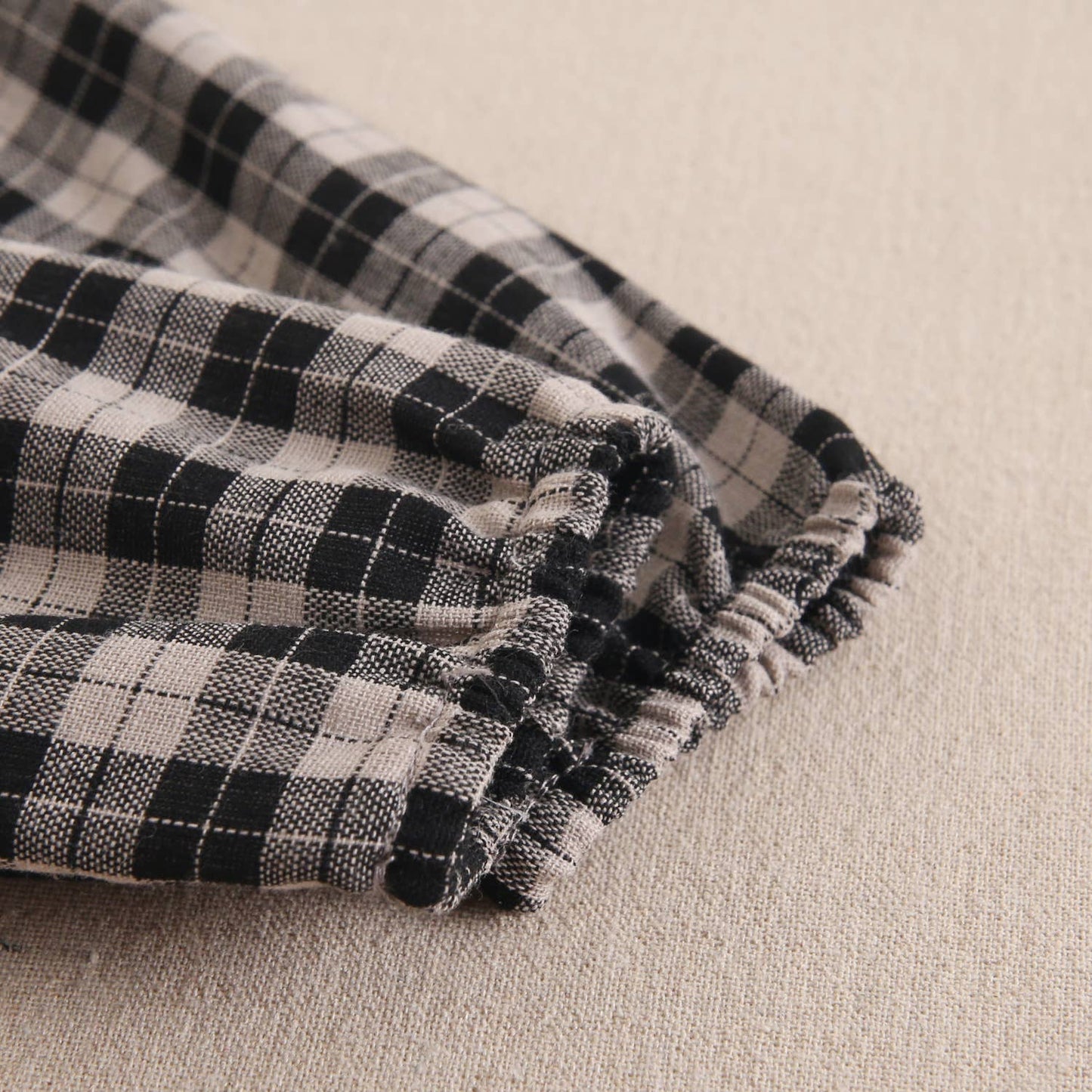 Robe pour bébé en beige clair et carreaux noirs