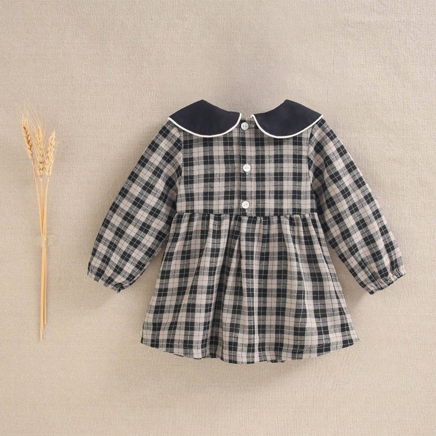 Robe pour bébé en beige clair et carreaux noirs
