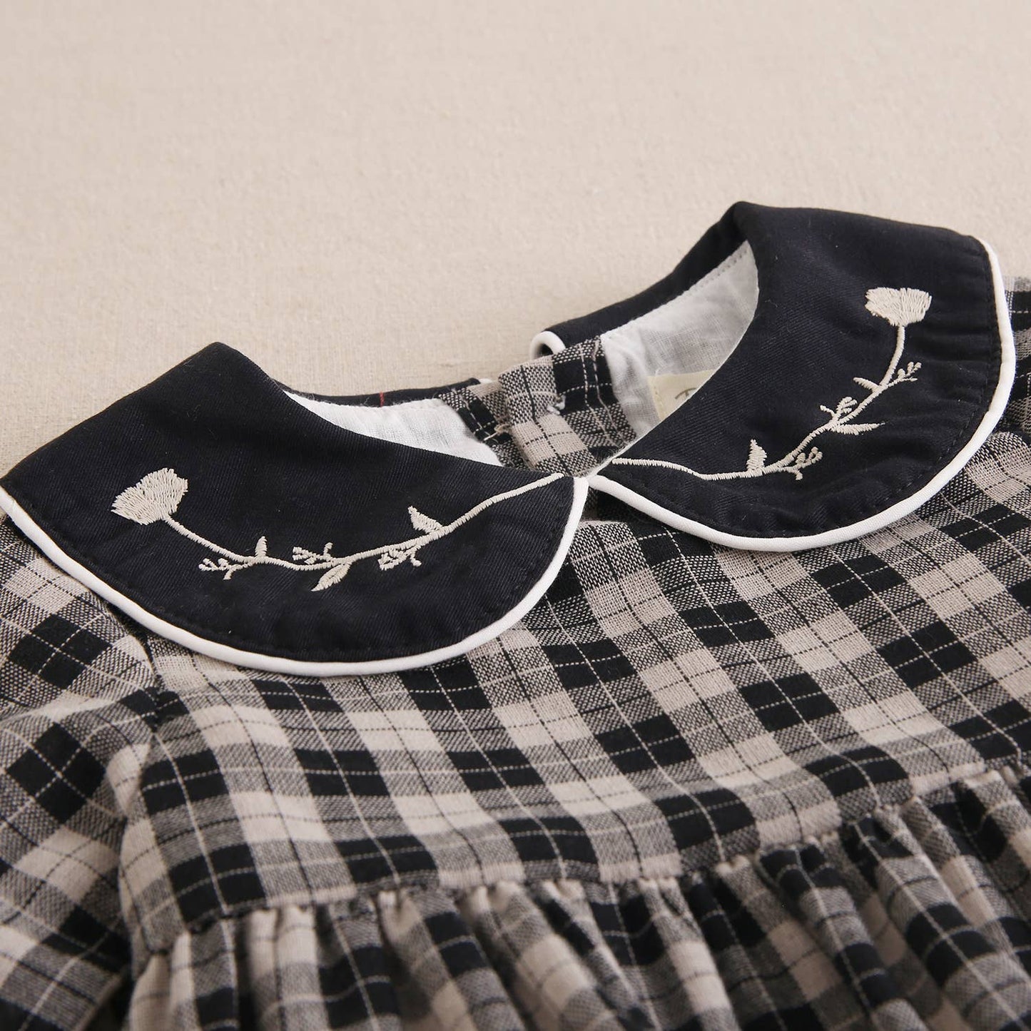 Robe pour bébé en beige clair et carreaux noirs